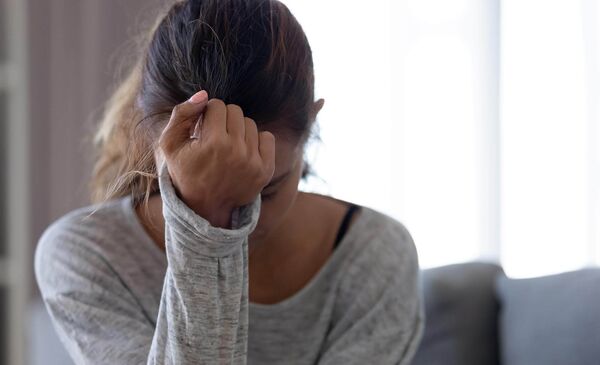 Foto: Depressive Frau (hält sich den Kopf/die Stirn)